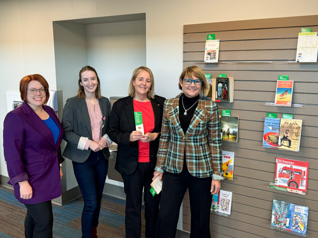 FIAA Manager of Public Relations and Marketing Kate O'Rourke, Communications Assistant Emma McCluskey, Director of the Fredericton Airport Julia Stewart and FIAA CEO Johanne Gallant, all smile in front of the Flybrary.