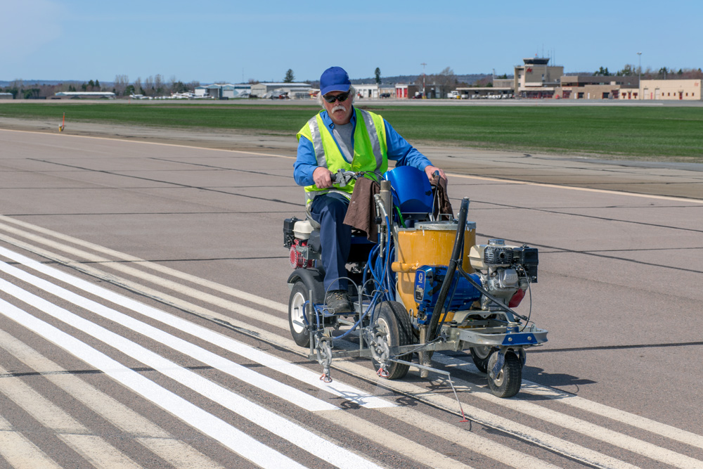 Lester re-paints the runway lines at the Fredericton International Airport