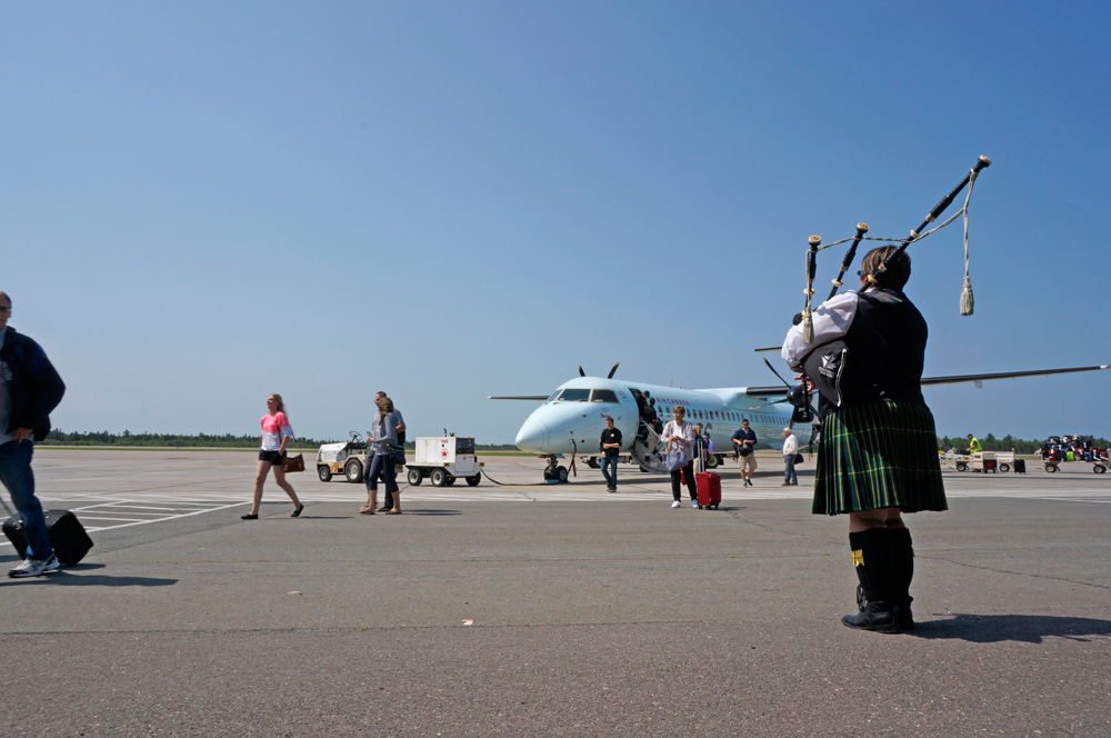 La cornemuseuse Megan Stewart joue pour les passagers qui arrivent à l’aéroport international de Fredericton le 25 juillet