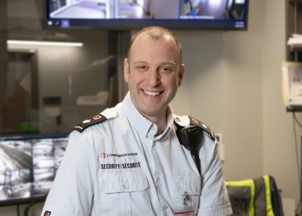 Steve Pelletier, Security Detail Supervisor at Fredericton International Airport (YFC), smiles at the camera in his office.