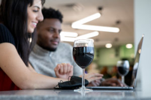 Des voyageurs autour d’un verre de vin au Chess Piece Pâtisserie and Café de l’aéroport international de Fredericton.