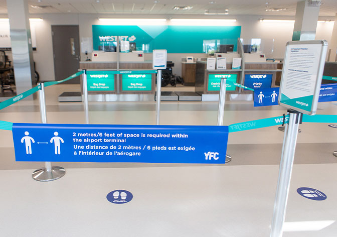 Air Canada counters in the Fredericton International Airport with physical distancing signage